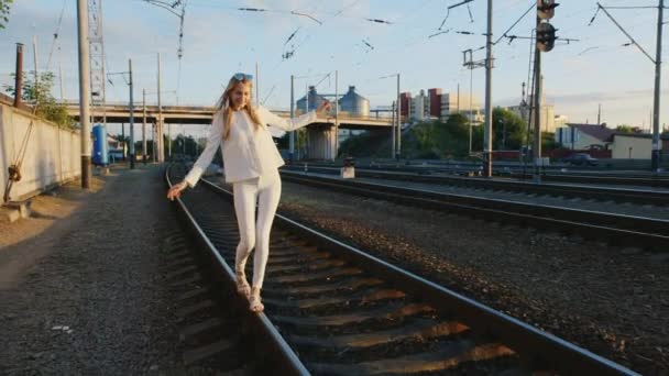 Young woman having fun. Walks by rail to rail, laughing — Stock Video