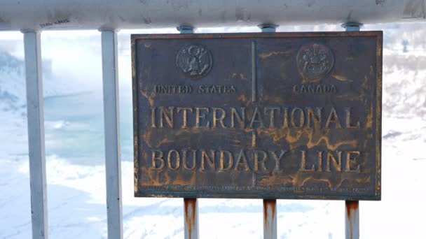 Niagara Falls, USA, February 2019: The tablet with coats of arms shows the line of the border between the USA and Canada on the Rainbow Bridge. The border runs along the middle of the Niagaar river — Stock Video