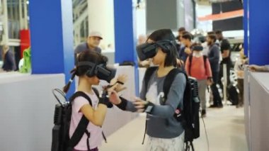 Toronto, Kanada, 20 Şubat 2018: İki kız sanal gerçeklik kask içinde oynamak. El ve el çantası arkadan sensörler