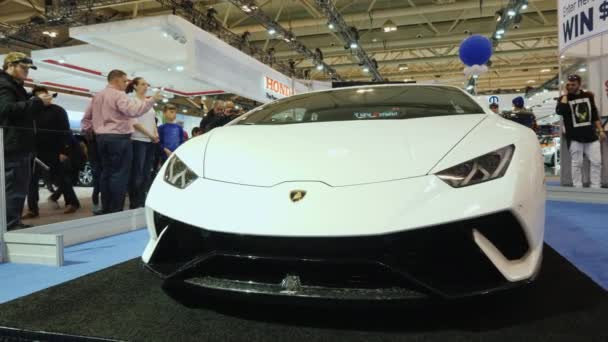 Торонто, Канада, 20 февраля 2018 года: Посетители восхищаются роскошным белым Lamborghini на выставке автомобилей в Торонто — стоковое видео