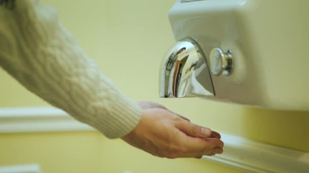 The man dries his hands under a stream of hot air. Hand dryer — Stock Video