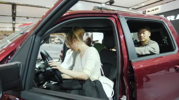 Toronto, Canadá, 20 de febrero de 2018: Una joven pareja multiétnica inspecciona el salón de un automóvil nuevo . — Vídeo de stock