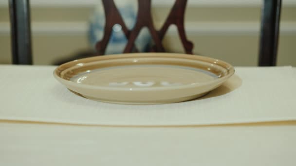 Жінка кладе срібні прилади - виделку і ніж біля тарілки. Розкішна домашня обідня обстановка — стокове відео