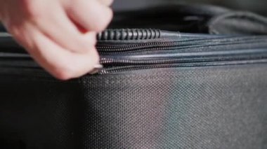 Seyahat ve Bagaj konsepti: mans el açar ve kapatır fermuar üstünde seyahat çantası.