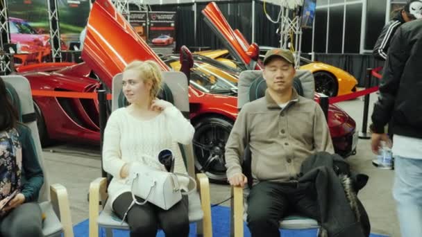 Toronto, Canada, februari 20, 2018: Een man en een vrouw ontspannen massage stoelen. Op de grote autoshow in Toronto — Stockvideo