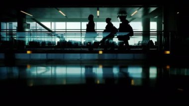 Havaalanı terminal insan siluetleri. Onların uçuş ve iş acele etseler. Pencerenin dışında bir uçan uçak görebilirsiniz