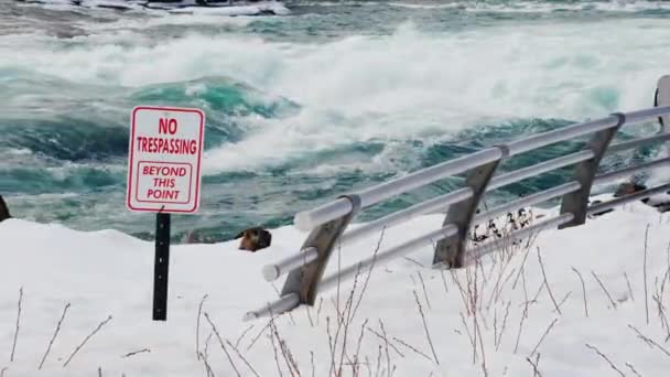 A sign with a warning about a dangerous place in the river. The stormy water of the Niagara River in front of the waterfall — Stock Video