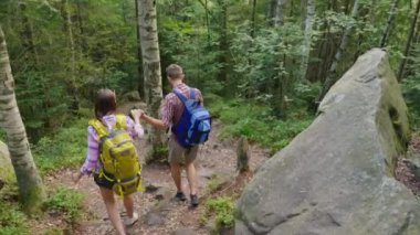 Çift dağ yoluna gidin. Bir adam aşağı gitmek, ona yardım et için bir kadın yardımcı olur. Arkadan görünüş