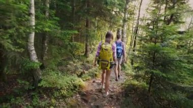 İki turist dar dağ yolunda yürümek. Güneş batmadan güzel parlıyor. Macera ve aktif bir şekilde yaşam