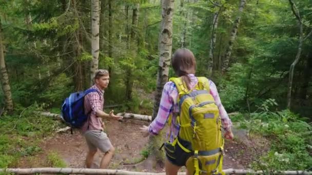 Een man en een vrouw naar beneden het bergpad. Een man geeft zijn hand aan zijn vriendin — Stockvideo