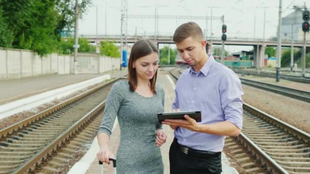 Colegas por trabajo en un viaje de negocios. Utilice una tableta en la plataforma de la estación — Vídeos de Stock