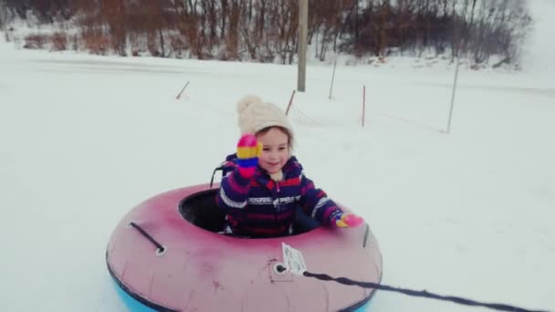 Niña en el anillo inflable paseos en la nieve, divertirse — Vídeo de stock