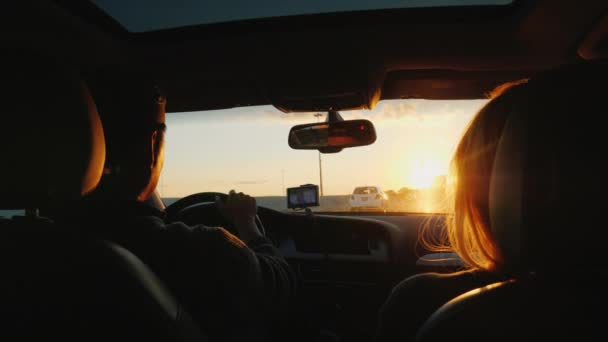 Una joven pareja multiétnica está conduciendo hacia el coche en una puesta de sol. La luz ilumina maravillosamente el cabello de las mujeres. Sueño con viajar concepto — Vídeos de Stock