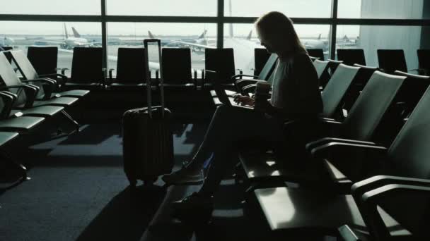 Mulher gosta de laptop e bebe café no terminal do aeroporto — Vídeo de Stock