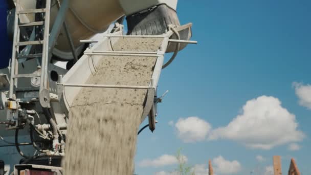 Het beton wordt verwijderd uit de betonmixer. Tegen de blauwe hemel. Bouw van landhuizen — Stockvideo