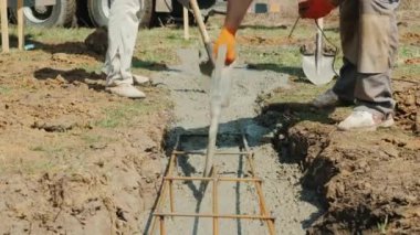 Bir işçi bir vibratör ve kürek ile beton mikser gelen alır. Şantiyede ağır el emeği