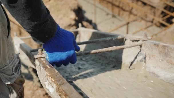 Ansicht von oben: Die Arbeiter führen die Rutsche mit der Hand in den Beton. Arbeiten am Fundament — Stockvideo
