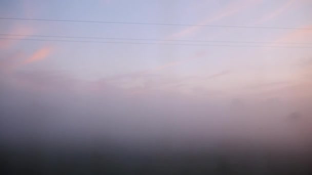 Uitzicht vanuit het raam van de trein - bos en vallei in de mist, vroege ochtend voor zonsopgang — Stockvideo