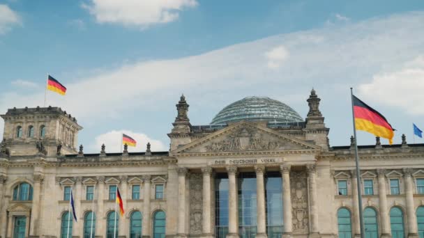 O edifício do Bundestag em Berlim. Bandeiras se desenvolvem no vento, um dia claro com belas nuvens — Vídeo de Stock
