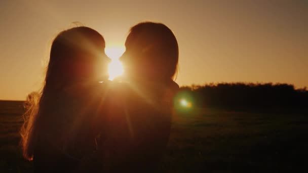 Moeder en dochter bij zonsondergang. Zacht kussen het meisje — Stockvideo