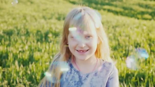 Criança feliz brincando com bolhas de sabão — Vídeo de Stock