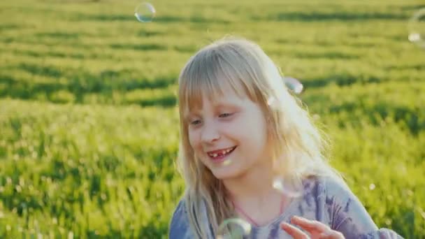 Blonde fille attrape des bulles de savon, des jeux d'été et du plaisir — Video