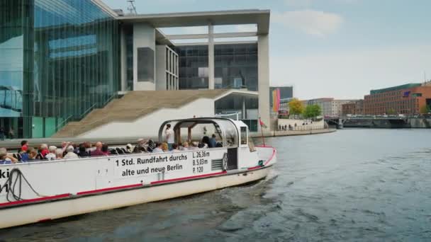 Berlijn, Duitsland, mei 2018: Een boot met toeristen zeilen langs de rivier. Mensen een bezoek aan de bezienswaardigheden, het nemen van foto 's — Stockvideo