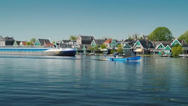 Zaanse Schans, Nederland, mei 2018: Een enorme aak zeilen tegen de achtergrond van de oude huizen in Zaans Schans. Transport en logistiek in Europa en Nederland — Stockvideo