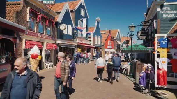 Volendam, Países Bajos, mayo de 2018: Los turistas pasean por las antiguas casas de pescadores, muchas tiendas de recuerdos y cafeterías callejeras — Vídeo de stock
