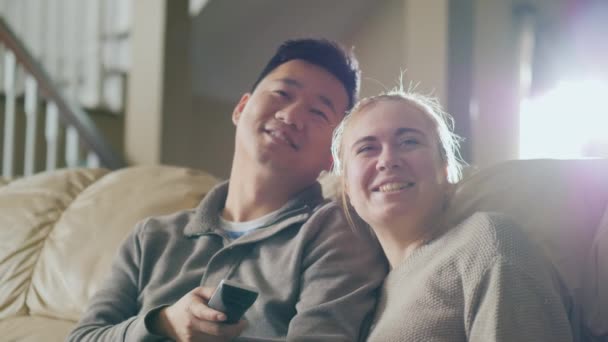 Bonjour à regarder la télé ensemble. Jeune couple assis sur le canapé, passer un bon moment ensemble — Video