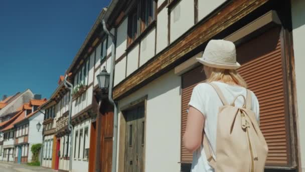 Турист з картою в руці йде вулицею гарного міста в Німеччині. Літні канікули в Європі — стокове відео