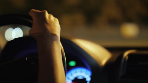 Conductora al volante de un coche, conduciendo por la ciudad nocturna — Vídeos de Stock