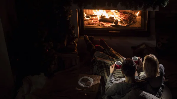 Romantik çift içkileri şöminenin yanında, üst tarafta.