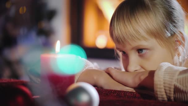 Retrato de un niño, mira una vela, pide un deseo en Nochebuena — Vídeos de Stock