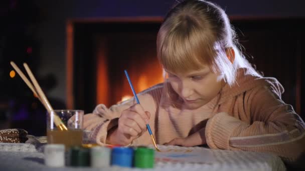 Child writes a letter to Santa Claus near the fireplace and Christmas tree. — Stock Video