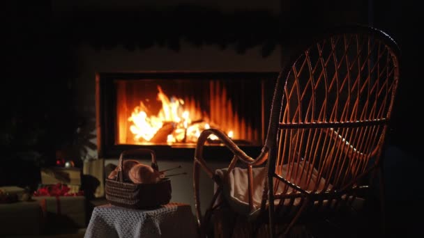 Schaukelstuhl und ein Set zum Stricken am Kamin. Schöner Abend zu Hause — Stockvideo