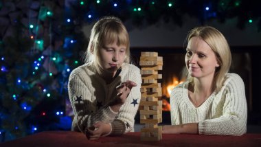 Anne ve kızı tahta bloklarla bir masa oyunu oynuyorlar.
