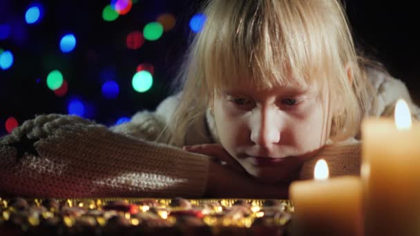 Retrato de una chica mirando una caja de chocolates en la noche de Navidad — Vídeo de stock