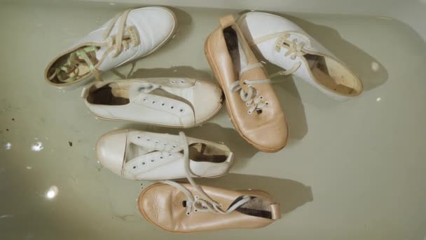 Chaussures sales pour femmes flottant dans la baignoire et la sève — Video