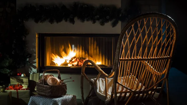 An empty rocking chair sways by the fireplace, next to a set for needlework. A place for winter holidays — Stock Photo, Image