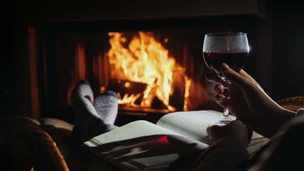 Sitting by the fireplace with a blank notebook and a glass of wine - planning a new life concept — Stock Video