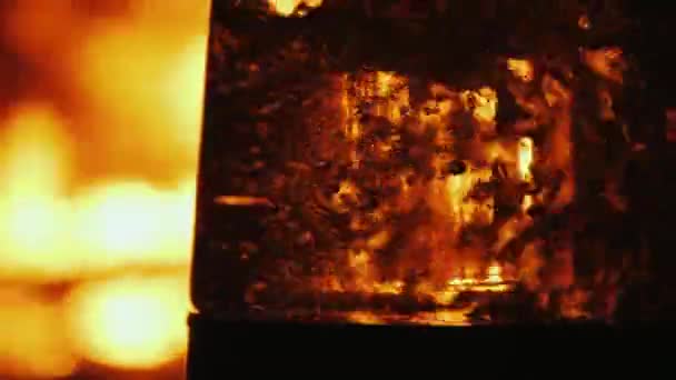 Кипящая вода в прозрачной посуде на фоне открытого огня в камине — стоковое видео