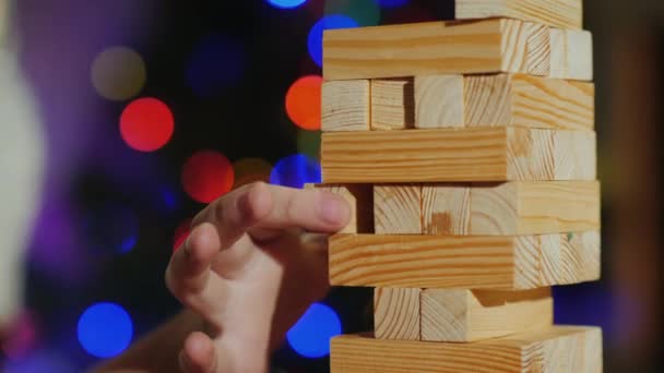 Pulling a wooden block out of the tower is a game for training accuracy — Stock Video