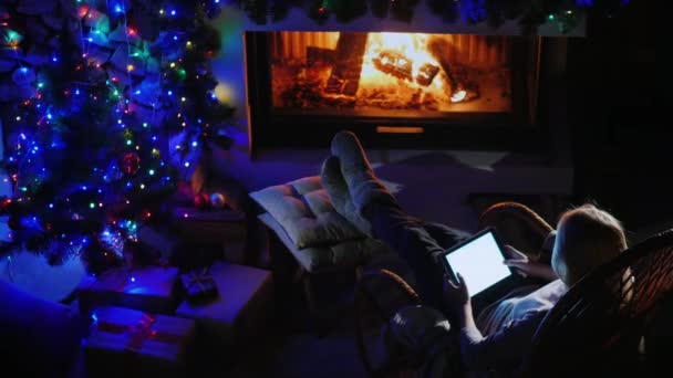 Top view of Young woman resting by the fireplace, using a tablet — Stock Video