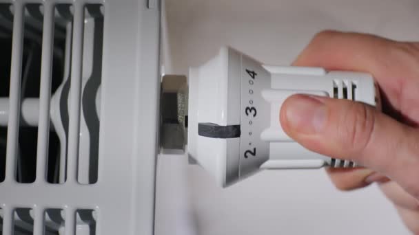 Man sets the temperature of the radiator in the room, energy saving concept — Stock Video