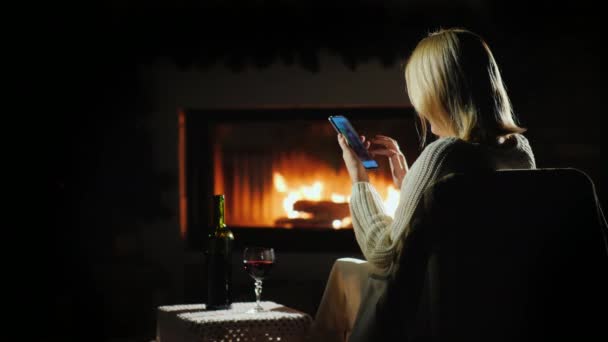 暖炉のそばで快適な雰囲気の中でオンラインショッピング女性 — ストック動画