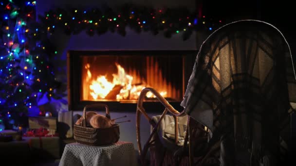 Een lege schommelstoel zwaait bij de open haard, naast een set voor handwerk. Een plek voor de wintervakantie — Stockvideo