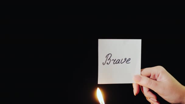 男人燃烧着印有"勇敢"字样的纸 — 图库视频影像