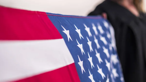 Der Junggeselle hält die amerikanische Fahne in der Hand — Stockfoto