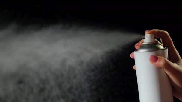 Mano con un aerosol puede rociar sobre un fondo negro — Vídeo de stock